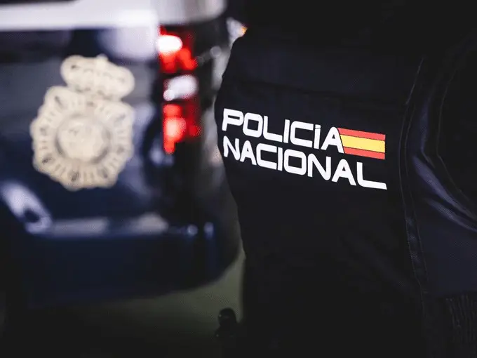 Nach Fahndung: EU-Haftbefehl auf Teneriffa vollstreckt in Beamter der spanischen Nationalpolizei steht in Uniform vor einem Streifenwagen im Süden von Teneriffa.