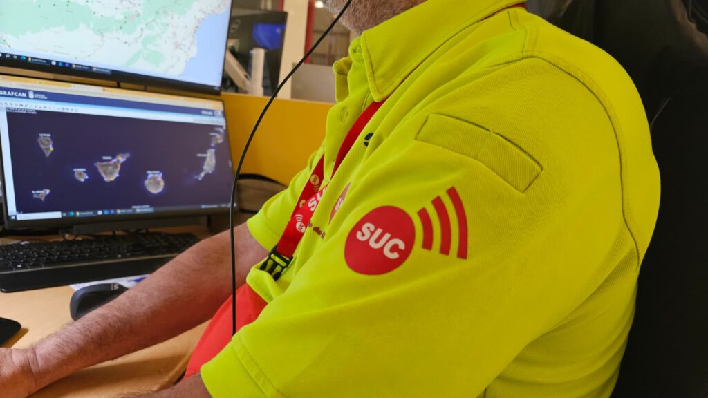 Unfall-Drama auf Gran Canaria: Fahrer bedroht Retter Ein Rettungssanitäter arbeitet mit Kopfhörern an den Bildschirmen in einer modernen Notrufzentrale.