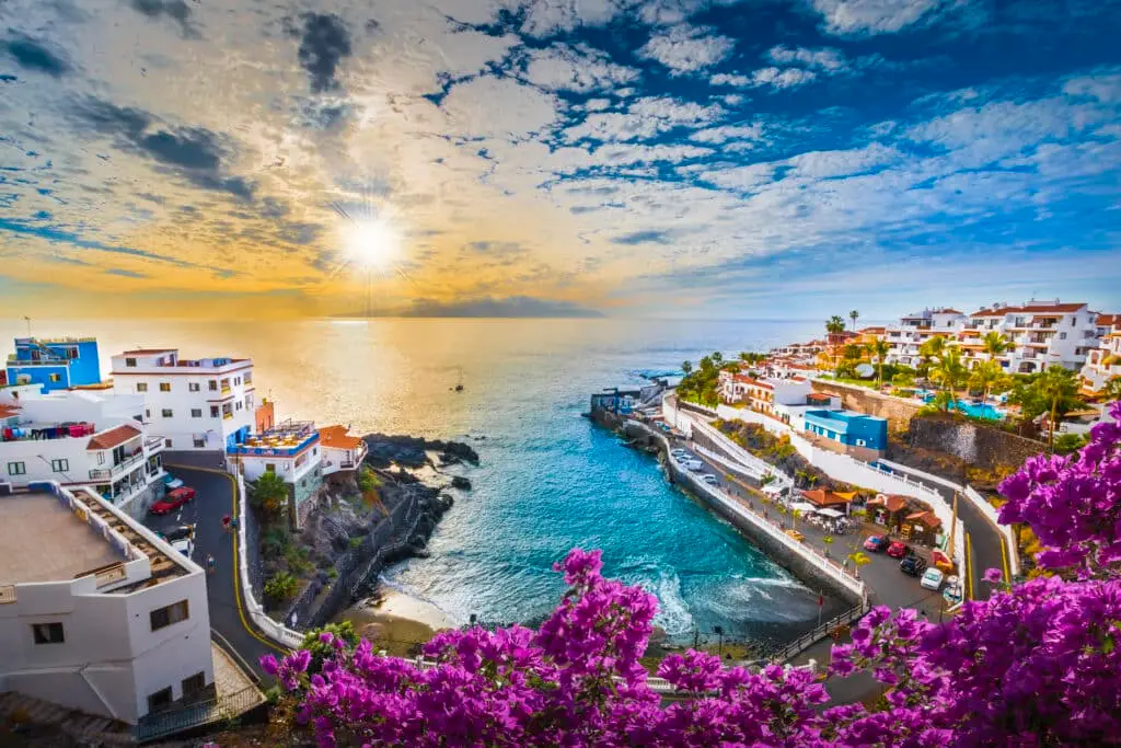 Zivilschutz ruft Hitze-Alarm für die Kanaren aus Morgenstimmung an der Westküste: Der Sonnenaufgang taucht die Gebäude von Puerto de Santiago nahe Los Gigantes in ein warmes Licht.
