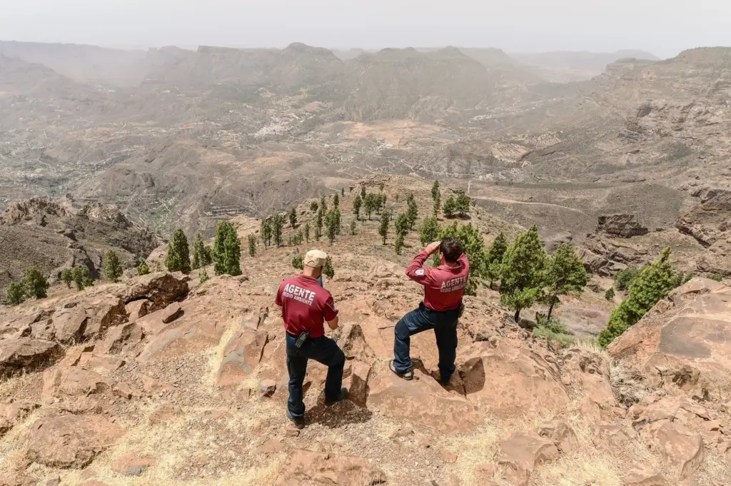 Brandrisiko auf Gran Canaria steigt auf absolutes Maximum Zwei Parkranger der Umweltschutzbehörde überwachen mit einem Fernglas die ausgetrockneten Berge und Täler auf Gran Canaria bei hoher Waldbrandgefahr.