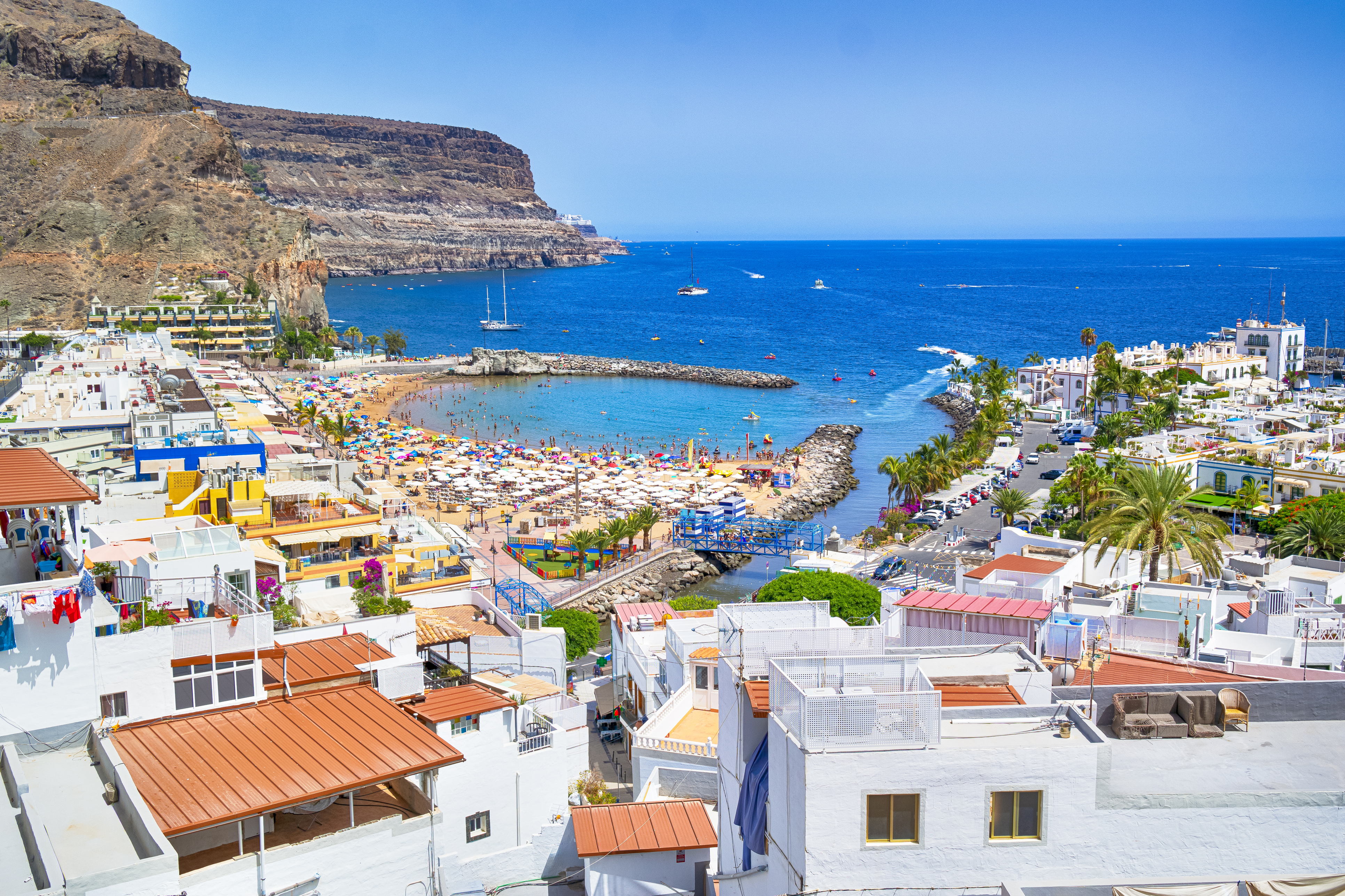Wetter-Kanaren: Leichte Abkühlung nach Rekord-Hitze Die malerische Küste und Boote im Hafen von Puerto de Mogán auf Gran Canaria bei Sommerwetter.